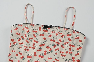 Detail of floral camisole showing cherry print and black bow on square neckline