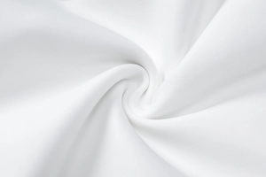 Close-up of white knit fabric texture showing detail of the ruffled hem dress