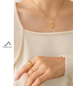 Detailed view of 18K gold plated mechanical rabbit necklace and rings on a model