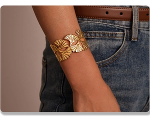 Golden ginkgo leaf cuff bracelet on model wrist with an elegant 18k gold plated finish