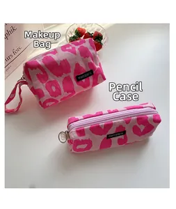 Detalle de neceser y estuche de pana rosa con estampado de leopardo y cremalleras