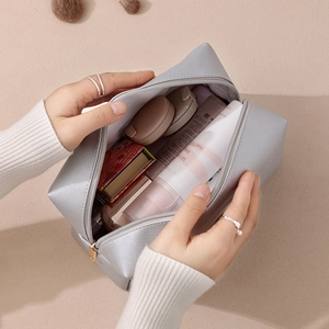 Large silver cross-grain PU makeup bag with zipper closure shown with cosmetics inside