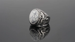 Close-up of vintage stainless steel ring featuring white turquoise and engraved details