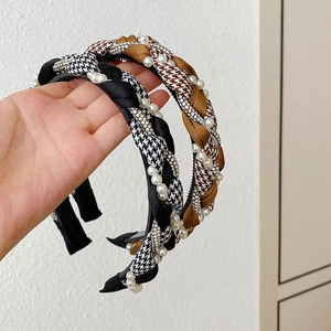 Close-up of braided sponge headbands in black and houndstooth with pearls and rhinestones