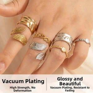 Detail of multi-set angel wing and heart rings in gold and silver finish on silk