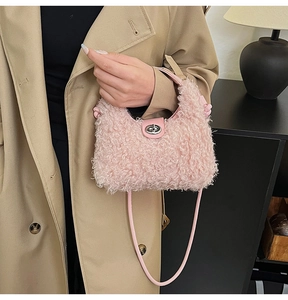 Detailed close-up of pink plush handbag with leather handle and metal twist lock