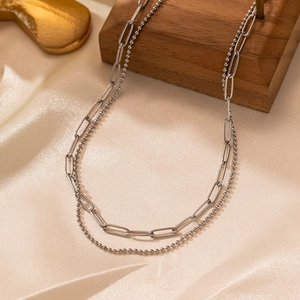 Detail of silver double-layered necklace featuring paperclip and bead chain designs