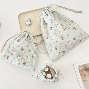 Detailed set of three green checkered drawstring pouches with cute cartoon prints
