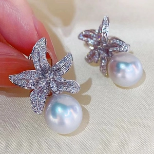 Starfish pearl drop earrings with sparkling zircon stones on a soft silk background