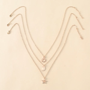 Vue détaillée du collier triple épaisseur or rose avec charms soleil lune étoile