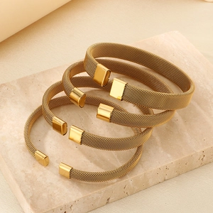 Lussuosi bracciali a rete intrecciata placcati oro 18K impilati su marmo