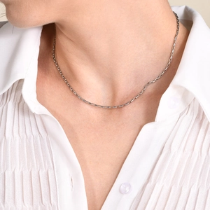 Minimalist silver stainless steel box chain necklace worn by a model on a white shirt