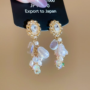 Detailansicht goldener Blumenstecker mit ovalem Kristall und Barockperlen-Quaste