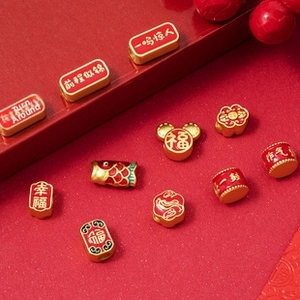 Macro shot of gold and red enamel lucky charms with traditional Chinese blessings