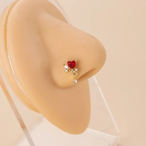 L-shaped gold nose stud featuring a red heart stone and crystal dangle on a model