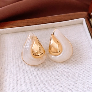 Macro view of teardrop resin earrings with 18K gold plated metal inlay in jewelry box