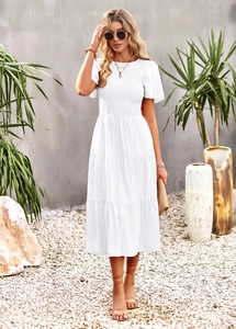 Detail of the high-waist white summer dress with layered ruffled skirt and short sleeves