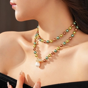 Dettaglio collana di perle con chiusura in strass dorati e pendente in perla barocca