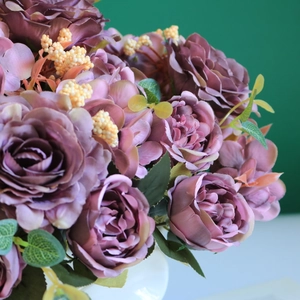 Close-up of artificial purple rose bouquet in a white vase with realistic silk petals