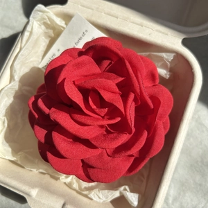 Elegant red fabric rose hair claw clip in a minimalist gift box with soft tissue paper