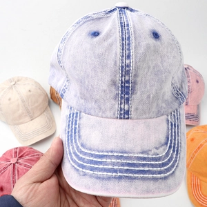 Detail of light blue washed cotton baseball cap with reinforced stitching and curved brim