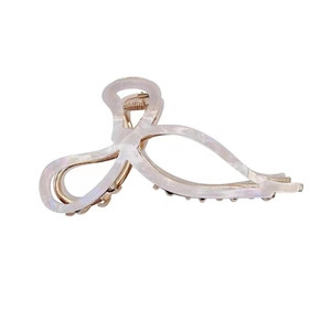 Pearlescent white acetate bow hair claw clip with golden metal accents for thick hair