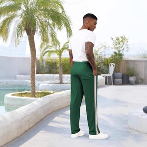 Men's dark green side stripe sports pants with white t-shirt in outdoor resort setting