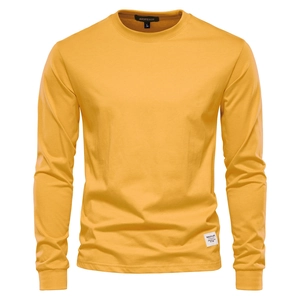 Close-up of white woven label on hem and brand print inside the ginger yellow T-shirt