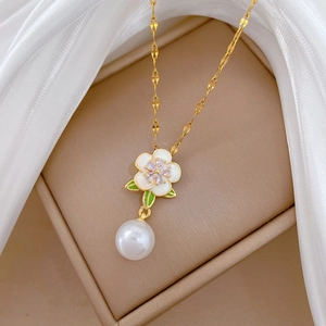 Collier élégant en acier titane doré avec pendentif fleur et perle dans un écrin marron