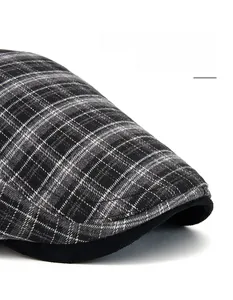 Dettaglio del cappello a quadri grigi con tesa larga rinforzata e trama di tessuto spesso