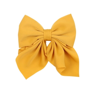 Detail of yellow fabric bow hair clip with high-quality texture and elegant drape
