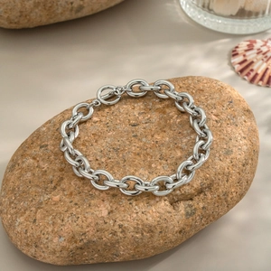Vue détaillée d'un bracelet à grosse chaîne en acier argenté avec fermoir OT sur pierre