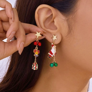 On-ear detail of festive Christmas earrings with Santa and bell charms for women