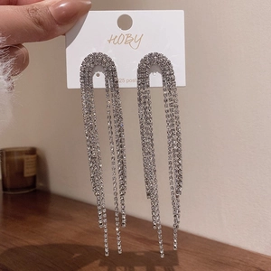 Détail de boucles d'oreilles pendantes argentées avec cristaux et tige en argent 925