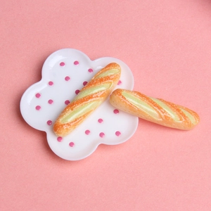 Mini baguettes en résine sur assiette à pois roses pour décoration de boulangerie