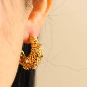 Détail d'une boucle d'oreille C en acier inoxydable plaqué or 18K avec des diamants