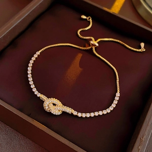Detail of gold knot bracelet with sparkling zircons and adjustable sliding clasp closure