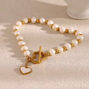 Detail of 18K gold-plated pearl bracelet with heart toggle clasp and white heart pendant