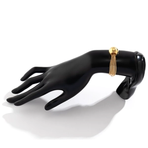 Detailed macro view of gold mesh chain bracelet with sphere charms on a black hand model