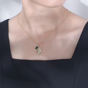 Elegant gold-plated silver necklace featuring an emerald zircon leaf pendant on a model