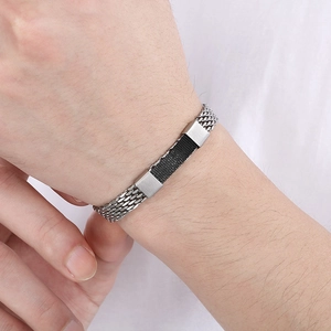 Detail of woven stainless steel snake chain bracelet in silver and black on male wrist