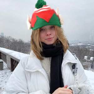 Detail of knitted Christmas elf hat with red and green stripes and pointed ears