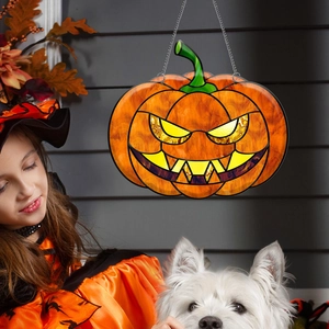 Detailed view of Halloween pumpkin ornament with metal chain in a festive window setting