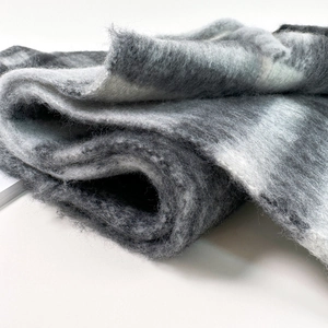 Close-up of grey gradient mohair scarf showing soft texture and long tassels