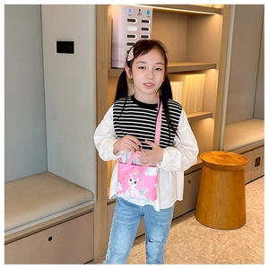 Pink unicorn kids crossbody bag with rainbow design shown on a little girl model