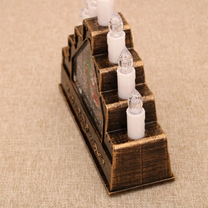 Detail view of a vintage bronze tiered Christmas LED candle holder with five white candles