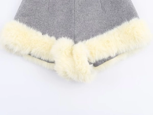 Detailed macro view showing grey wool fabric texture and cream faux fur trim stitching