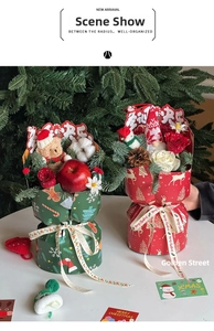 Christmas bouquet holder with red roses, pine cones, and teddy bear in holiday gift box