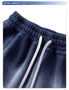 Dettaglio dei pantaloncini sportivi blu scuro con elastico in vita e coulisse bianche
