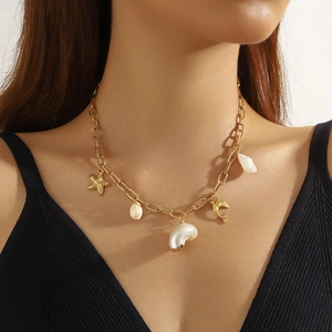 Bohemian gold-plated necklace with starfish, seashell, and dolphin pendants on model